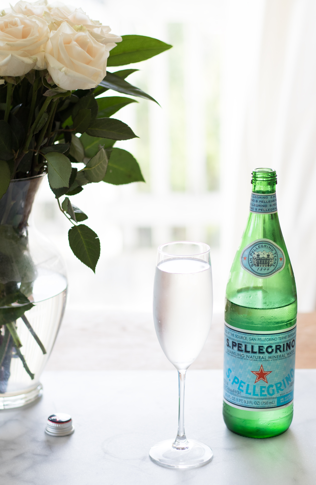 How to drink more water_Pellegrino, champ glass, and white roses_joyfetti.com